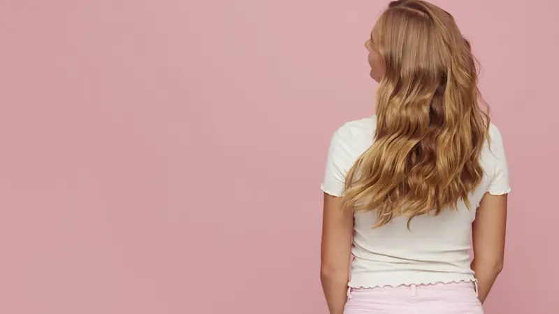 Cheveux longs ondulés et brillants après un brushing