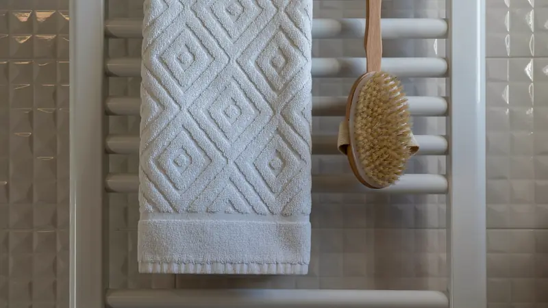 Serviette en coton et brosse suspendues dans une salle de bain