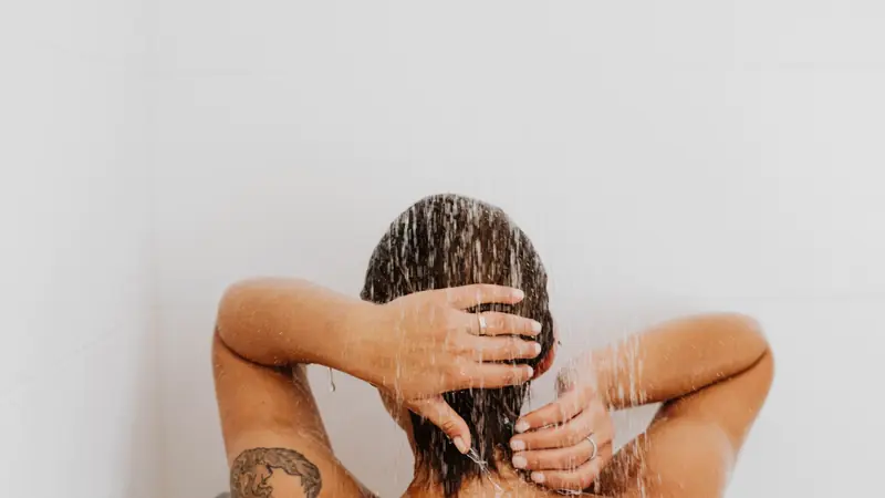 Femme qui se lave les cheveux sous la douche