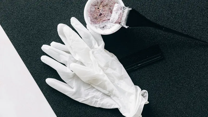 Gants, bol de coloration et pinceau sur un plan de travail