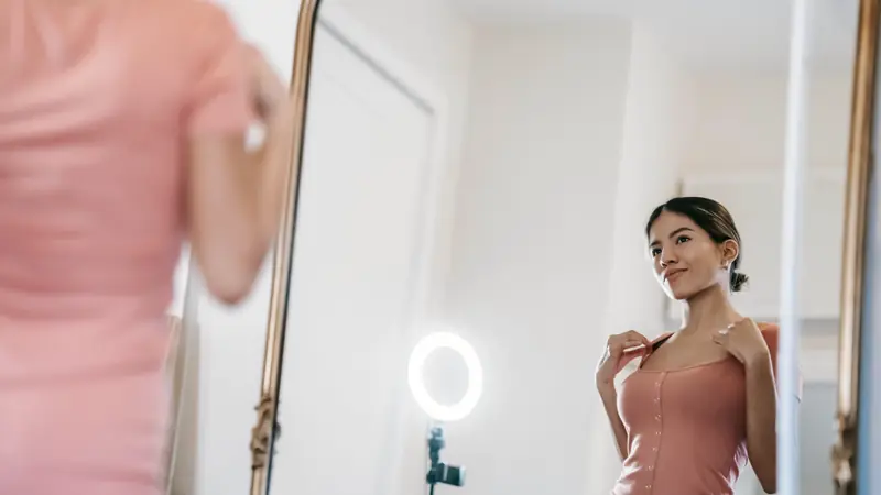 Femme qui se regarde dans un grand miroir