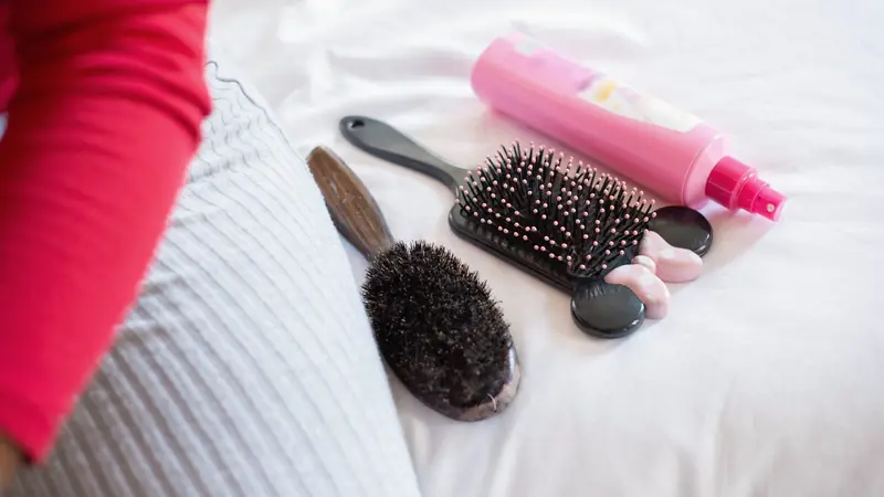 Brosses à cheveux posées sur un lit