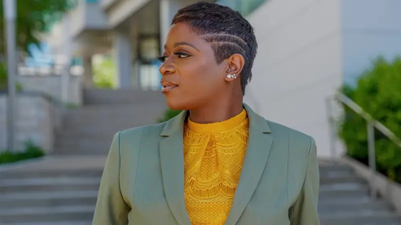 Femme aux cheveux très courts, de profil, en extérieur