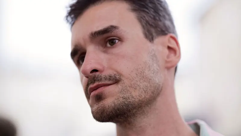 Homme vu de trois quarts, cheveux courts coiffés en texture sur le dessus et côtés plus courts au-dessus de l'oreille
