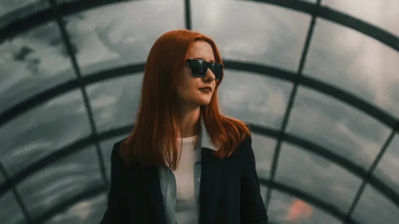 Femme aux longs cheveux roux cuivré, lunettes de soleil