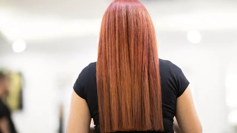Longs cheveux cuivrés parfaitement lisses, vus de dos